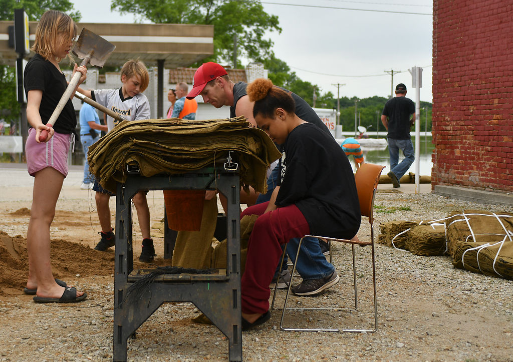 Sandbaggers continue to fill bags using their cone funnel contraption
